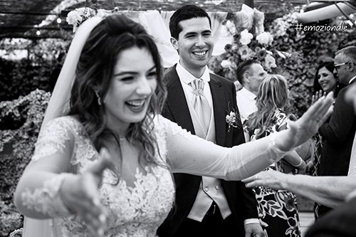 una foto emozionale di sposi felici che salutano