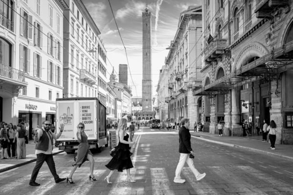 Sposi camminano in centro a Bologna con le due torri sullo sfondo